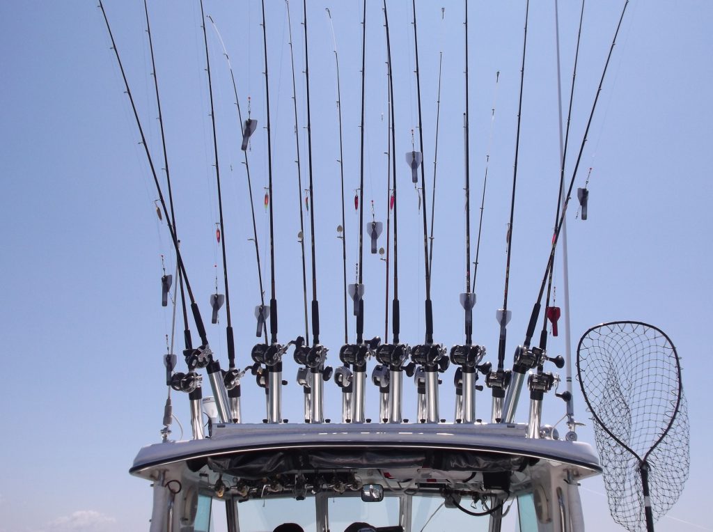 Fishing rods are stored on top of a charter boat roof ready to be used for fishing.