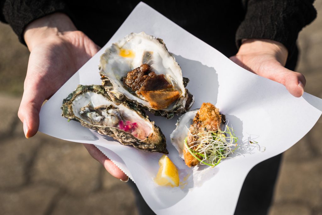Close up of raw, fried, and smoked gourmet oysters at a food festival