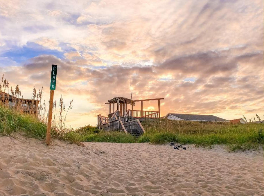 a gazebo on the beach facing the sunset